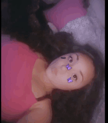 a woman with purple butterflies on her face is laying on a bed