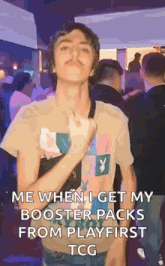 a young man in a playboy shirt is standing in a crowd of people and making a funny face .