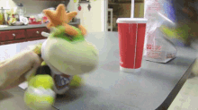 a stuffed animal is sitting on a counter next to a chick-fil-a cup with a straw