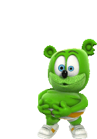 a green gummy bear with blue eyes is holding a ball