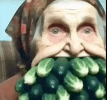 a woman with a scarf around her head is eating a bunch of green vegetables