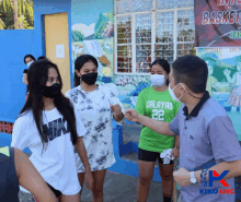 a man wearing a nike shirt shakes hands with a woman wearing a calayas 22 shirt