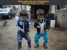 two young boys are dancing in front of a sign that says when you sad your friend have had too much to drink