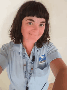 a woman wearing a blue shirt with a lanyard that says nalc on it