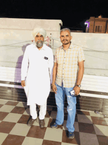 a man in a turban stands next to another man