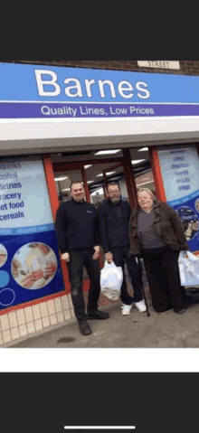 three people are standing in front of a barnes grocery store