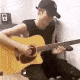 a man is playing an acoustic guitar in a room .