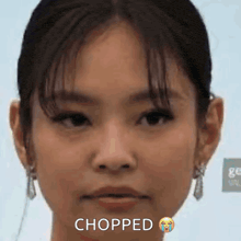 a close up of a woman 's face with the words chopped on it .