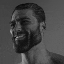 a black and white photo of a shirtless man with a beard and mustache smiling .