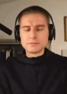 a man is wearing headphones and making a funny face .