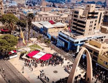 an aerial view of a city with a large group of people standing in a square .