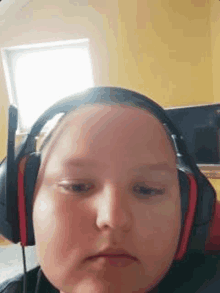 a young boy wearing headphones is making a face .