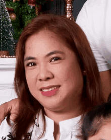 a woman in a white shirt smiles for the camera