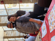 a man and a woman hugging each other in front of a table