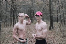 a shirtless man in a pink hat flexes his muscles