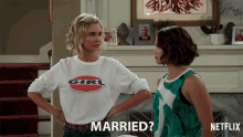 two women are standing next to each other and one of them has the word married on her shirt