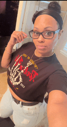 a woman taking a selfie wearing a black shirt that says " till death " on it