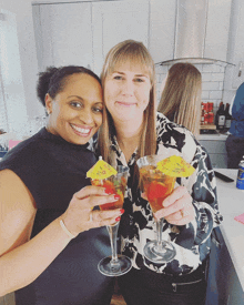 two women toasting with martini glasses with umbrellas