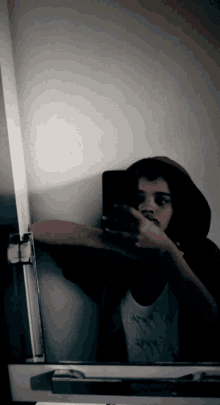 a person taking a selfie in front of a mirror with a hoodie on