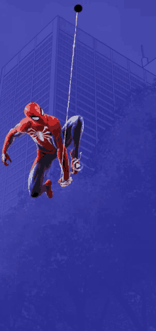 a spider man hanging from a rope with a blue background