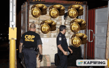 two cbp federal officers standing in front of a truck