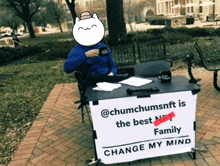 a man sits at a table with a sign that says " change my mind "