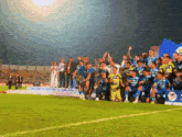 a group of soccer players are posing for a photo on a field with a sign that says ' liga ' on it