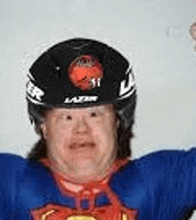 a man with down syndrome is wearing a helmet and a superman shirt .