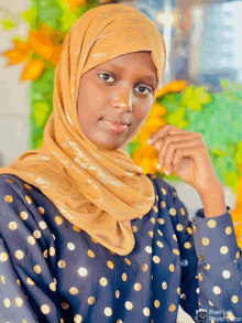 a woman wearing a polka dot shirt and a hijab has a pixel lab photo editor watermark on the bottom right