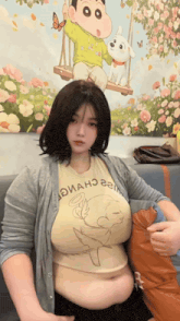 a woman is sitting in front of a painting of a boy on a swing with a dog