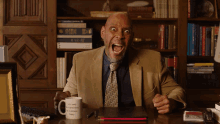 a man sitting at a desk with a mug that says " it 's a wonderful day to be a scientist "