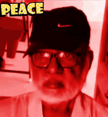 a man wearing glasses and a hat with the word peace written above him