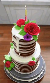 a cake with red roses and a candle on top