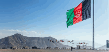 the flag of afghanistan is flying high in the wind