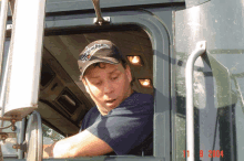 a man wearing a hat that says columbia is looking out of a truck window