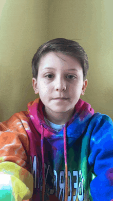 a young boy wearing a colorful tie dye hoodie that says georgia on it