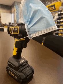 a flux cordless drill with a mask on top