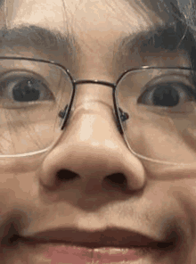 a close up of a person 's face with glasses on .