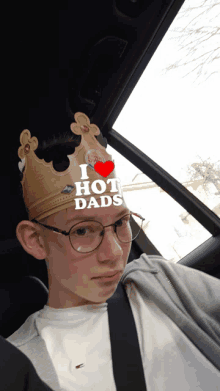 a boy wearing a crown that says i love hot dads on it