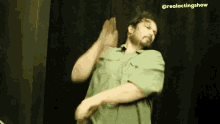 a man in a green shirt is dancing on a stage .