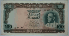 a one hundred rupees banknote with a man on it