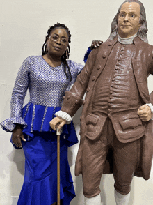 a woman in a blue dress stands next to a statue of franklin d. roosevelt