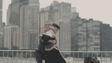 two people hugging in front of a city skyline with netflix written on the bottom