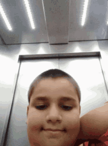 a boy is taking a picture of himself in an elevator