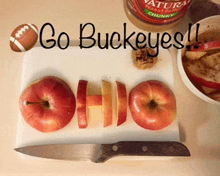 a cutting board with sliced apples and the words " go buckeyes "