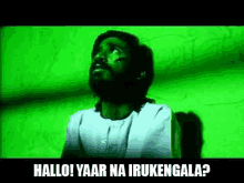 a man is sitting in front of a green wall with the words hallo yaar na irukengala written on the bottom