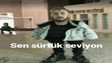 a man wearing roller skates is standing in front of a building that says sen sirtuk seviyon