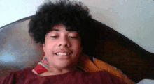 a young boy with curly hair is laying on a bed