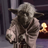yoda is holding a pair of glasses in his hand
