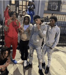 a group of young men are posing for a picture with one wearing a lacoste sweatshirt